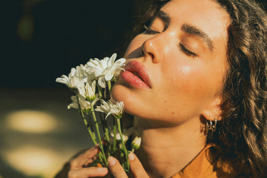 Eine Frau riecht an einer Blume