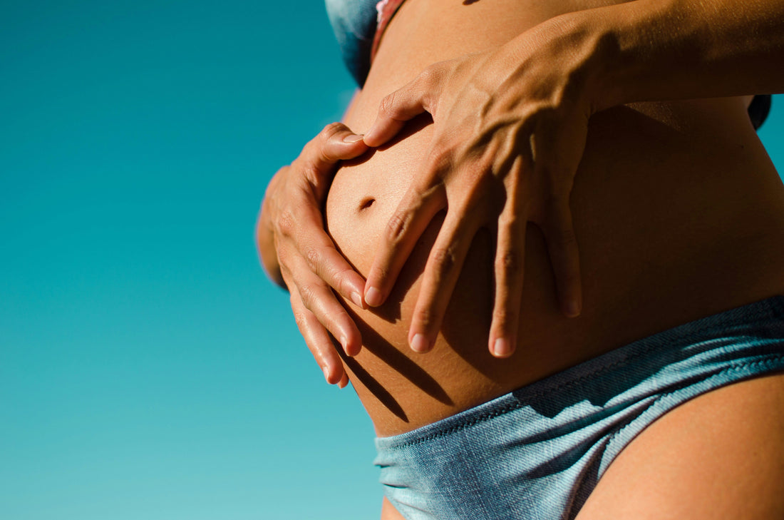 Schwangere Frau berührt ihren Bauch